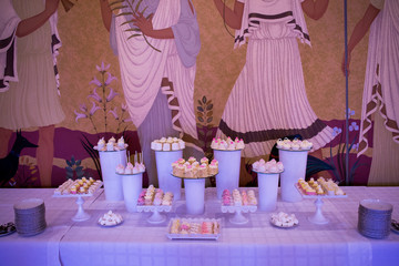 Candy bar served with cupcakes on white vases