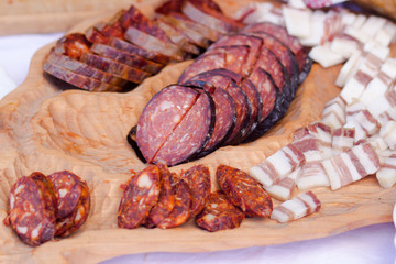 red sliced sausage on wooden board