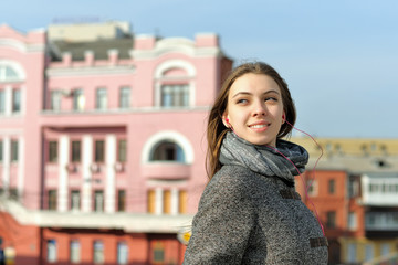 Portrait of a girl who listens to music walking around the city