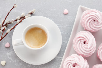 Cup of espresso coffee and homemade zephyr or marshmallow in a white plate on stone background