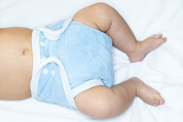Bauch, Beine und Füße eines kleinen Babys mit Stoffwindel