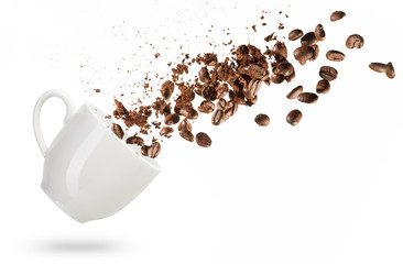 Les grains de café renversés d& 39 une tasse isolé sur fond blanc