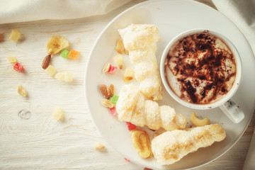 Cup of hot cocoa and cream cakes
