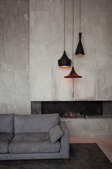 Gray velour sofa in a dark room the bright light from eternal light, and artificial fireplace....