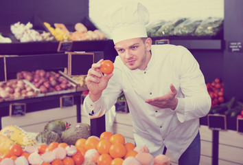 Cook deciding on best fruits in grocery store