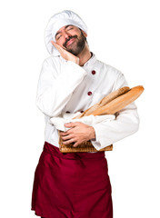 Young baker holding some bread and making sleep gesture