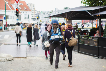 Travelers with backpacks are walking around the city.
