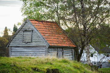 Fototapeta na wymiar Old wooden house with a red roof in Scandinavia.
