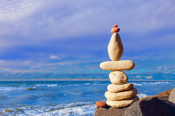 stones balance on the background of the sunset sky on the beach