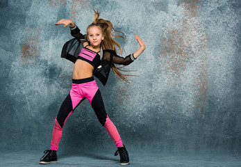 Fototapeta na wymiar Young girl break dancing on wall background.