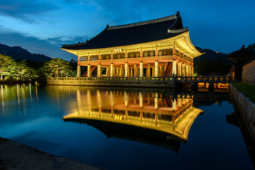 Obraz premium Pałac Gyeongbokgung nocą w Korei Południowej, z nazwą pałacu „Gyeongbokgung” na znaku