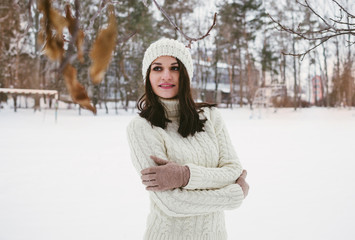 Portrait of young beautiful female in winter snowy park