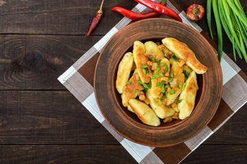Popular traditional Czech, Hungarian, German dish: potato knedli (dumplings) with slices of fried bacon, spicy red pepper and green onions. The top view