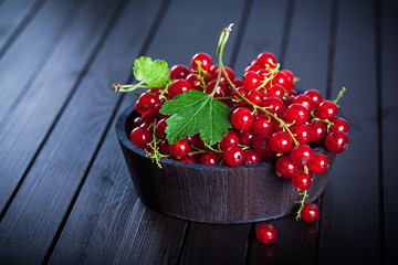 Ripe red currant in wooden bowl