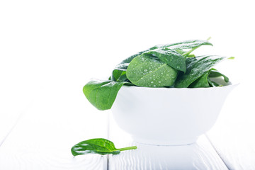Fresh raw spinach in white bowl