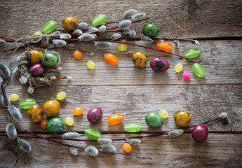 Easter eggs and willow branches on wooden background