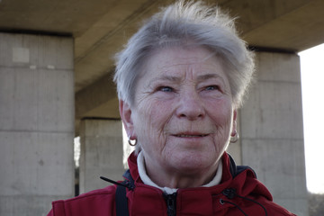 portrait von einer älteren frau unter einer brücke