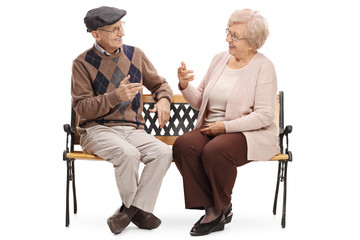 Seniors sitting on a bench and talking with each other