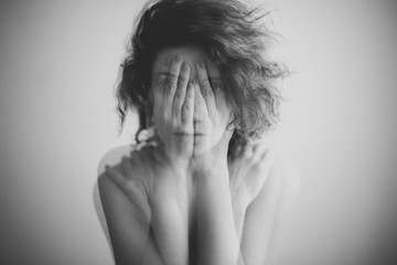 Double exposure black and white portrait of a woman covering her face and eyes with her hands  - 140076283