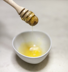 Honey Dripping From Dipper In Bowl