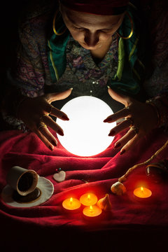 Female fortuneteller with her hands above crystal ball