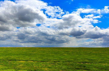 Obraz premium Realistic blue cloudy sky with bright sun over green meadow field