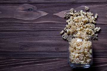 Raw macaroni, spaghetti on an old wooden table. Mix of pasta. Close up