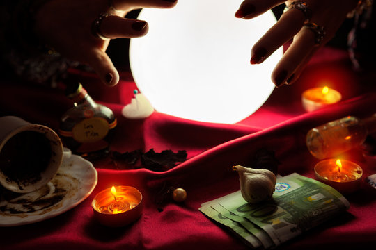 Hands of fortune teller around crystal ball
