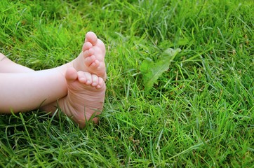 Children crossed legs in the grass. Space for some text. Child concept.