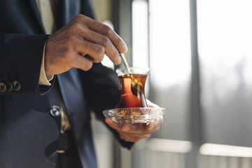 Businessman holding glass of Turkish tea