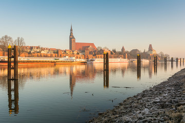 Fototapeta premium Kirche St Stephan und Tangermünde im Sonnenaufgang, Sachsen Anhalt in Deutschland