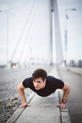 Man doing push ups in urban environment 