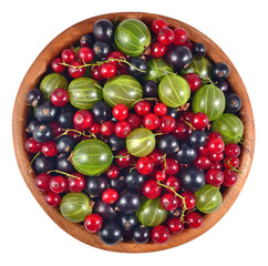Various kinds of fresh berries in a wooden bowl on a white