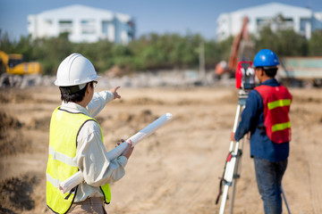 Civil Engineers At Construction Site and A land surveyor using an altometer