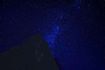 Fototapeta na wymiar Mountain peak in the dark night with starsdust background