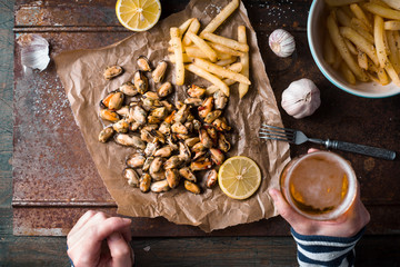 Drinking beer with mussels and French fries top view