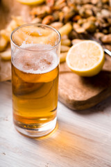 Glass of beer with blurred snack on the white wooden table