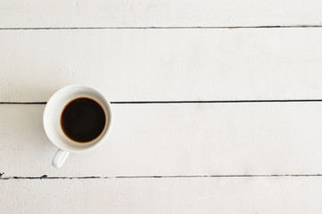 cup of coffee on white table wood background