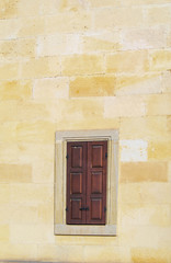 Fototapeta na wymiar brown window frame on the wall of a house made of stone.