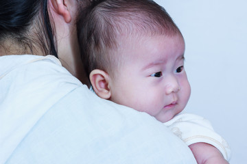 Asian girl resting on her mother's shoulder. Mother's Day celebration.