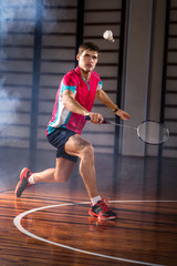badminton athlete hits a shuttlecock in the gym - obrazy, fototapety, plakaty