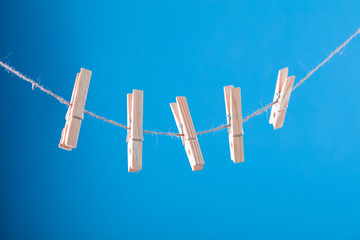 Blank card pinned on clothesline. Coppy space for wordings. Pinned with flower pins. Blue, orange background. High resolution photo.