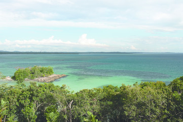 High panoramic point of view looking over the turquoise tropical ocean horizon in the afternoon of belitung island, Indonesia.