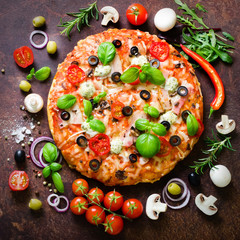 Food ingredients and spices for cooking mushrooms, tomatoes, cheese, onion, oil, pepper, salt, basil, grater, olive and delicious italian pizza on rustic background. Copyspace. Top view. Square