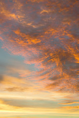 Sky filled with dark and light orange colored clouds during sunset.