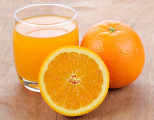 Fresh orange juice on wooden table background