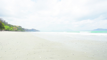 Empty white sand beach and clear blue ocean waves at Bajawa Ruting Flores in the morning.