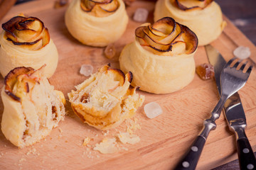 Fresh cinnamon buns with apples on the rustic wooden background. Shallow depth of field.