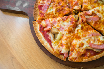 Pizza ham with mushrooms on wood table.