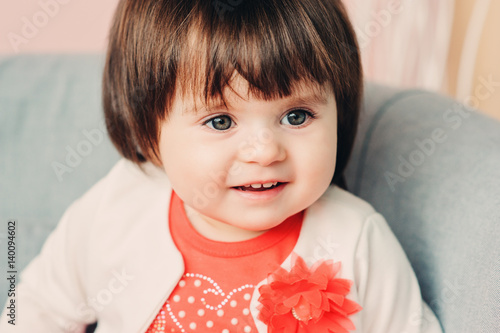 close up indoor portrait of cute happy 1 year old baby girl